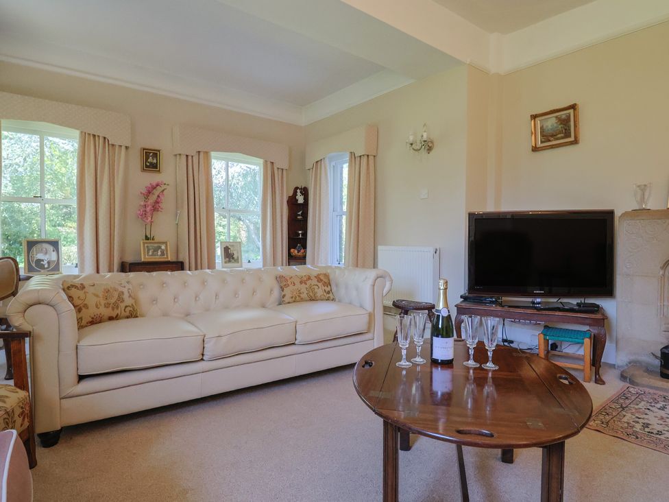 A living room with a sofa and television at Goulds Farmhouse in Milborne St Andrew