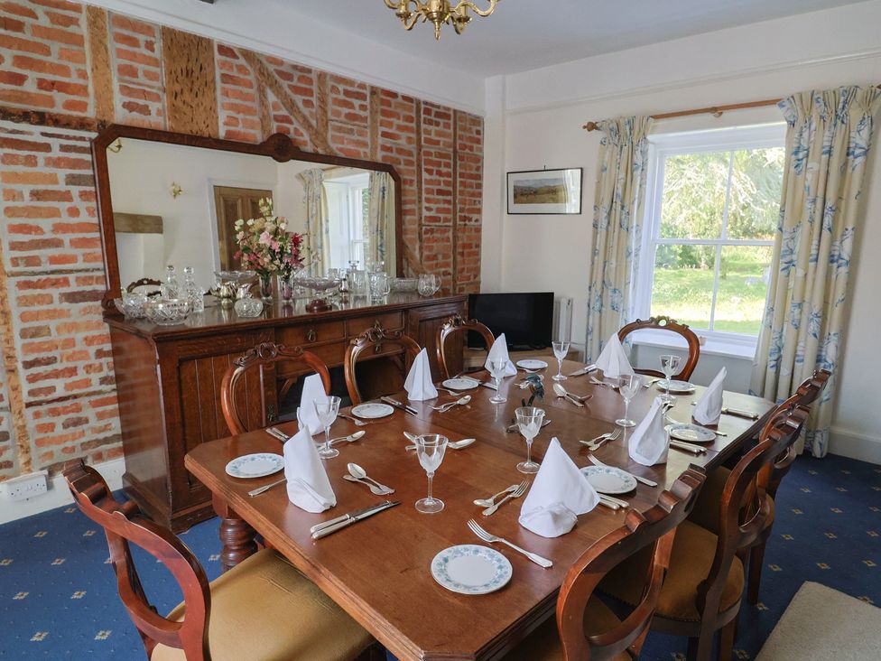 A dining room with a large table and chairs at Goulds Farmhouse Milborne St Andrew
