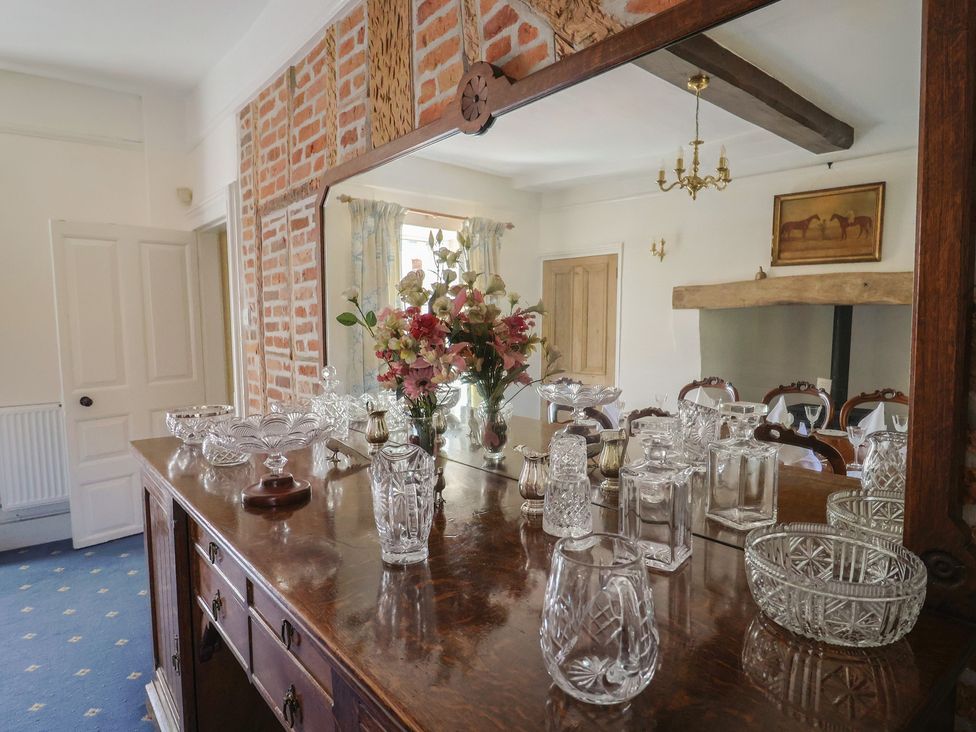 A dining room with a sideboard and mirror at Goulds Farmhouse in Milborne St Andrew