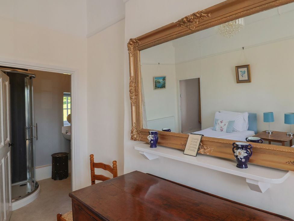 A bedroom with a mirror and a shower at Goulds Farmhouse in Milborne St Andrew