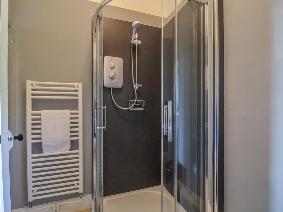 A bathroom with a shower and towel radiator at Goulds Farmhouse in Milborne St Andrew