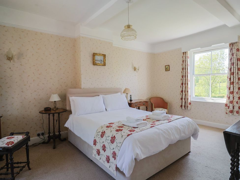 A bedroom with a bed and bedside table at Goulds Farmhouse in Milborne St Andrew