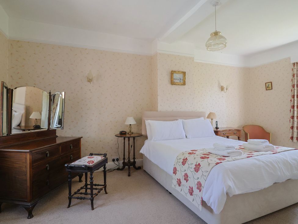 A bedroom with a bed and a dressing table at Goulds Farmhouse in Milborne St Andrew