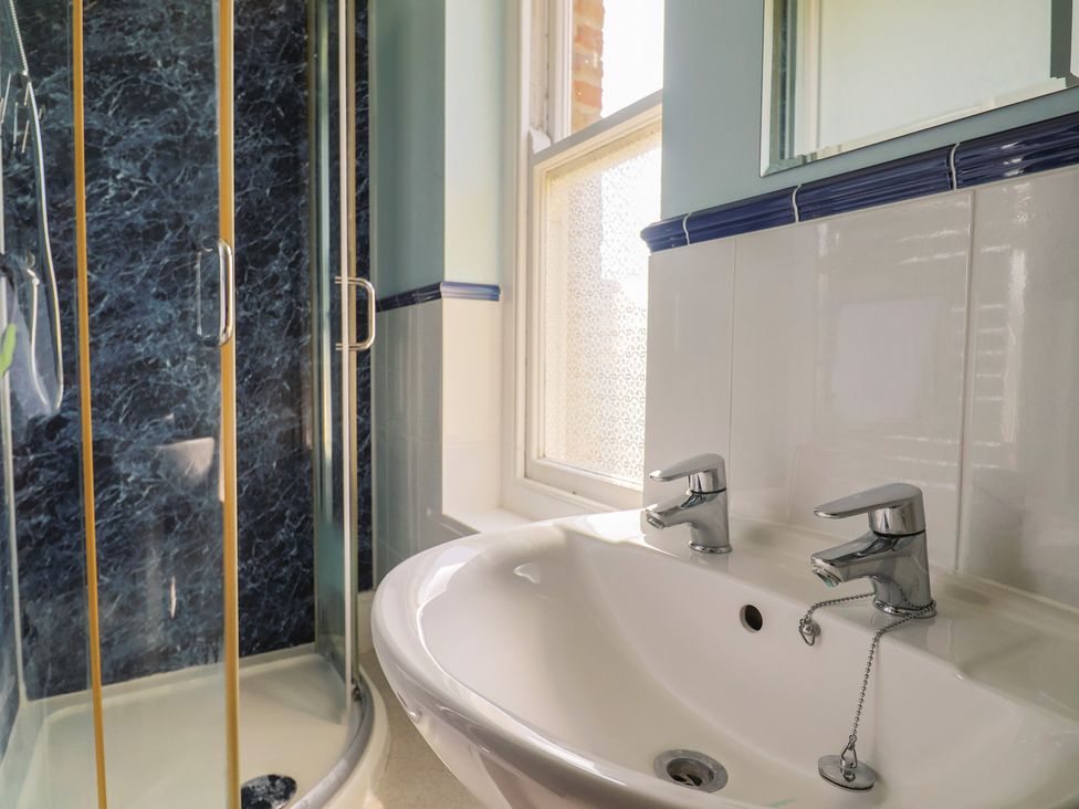 A bathroom with a shower and sink at Goulds Farmhouse in Milborne St Andrew