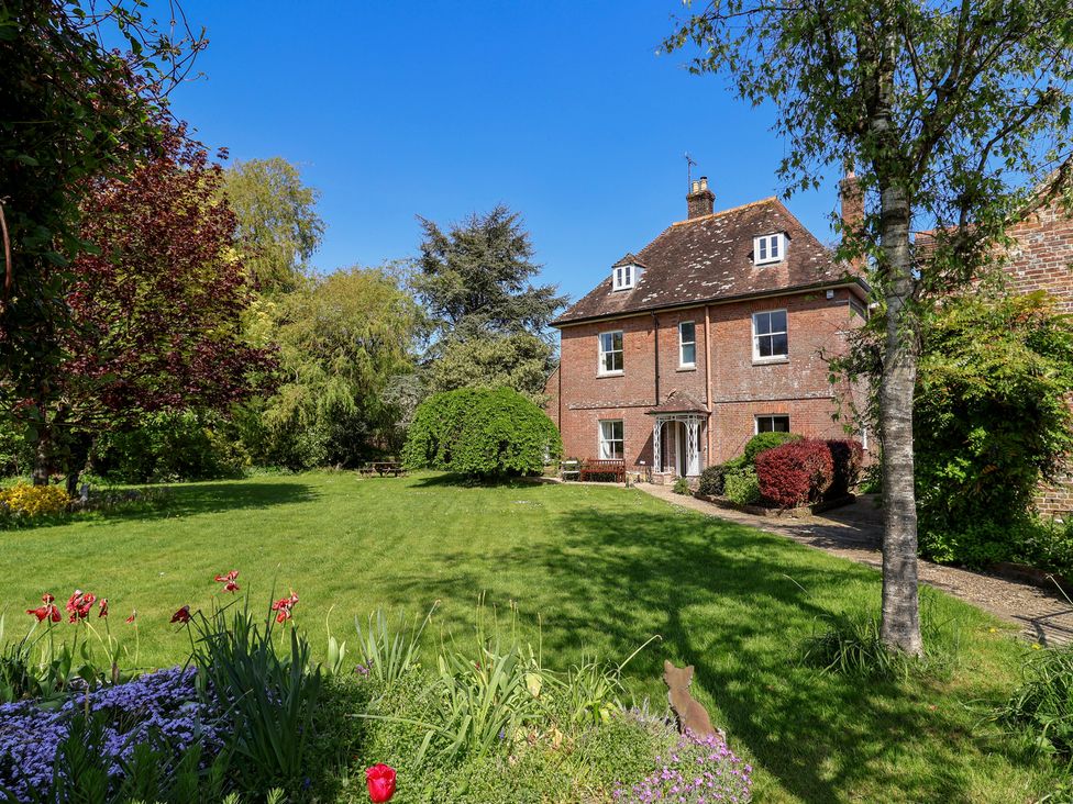 A garden with a house and trees at Goulds Farmhouse Milborne St Andrew