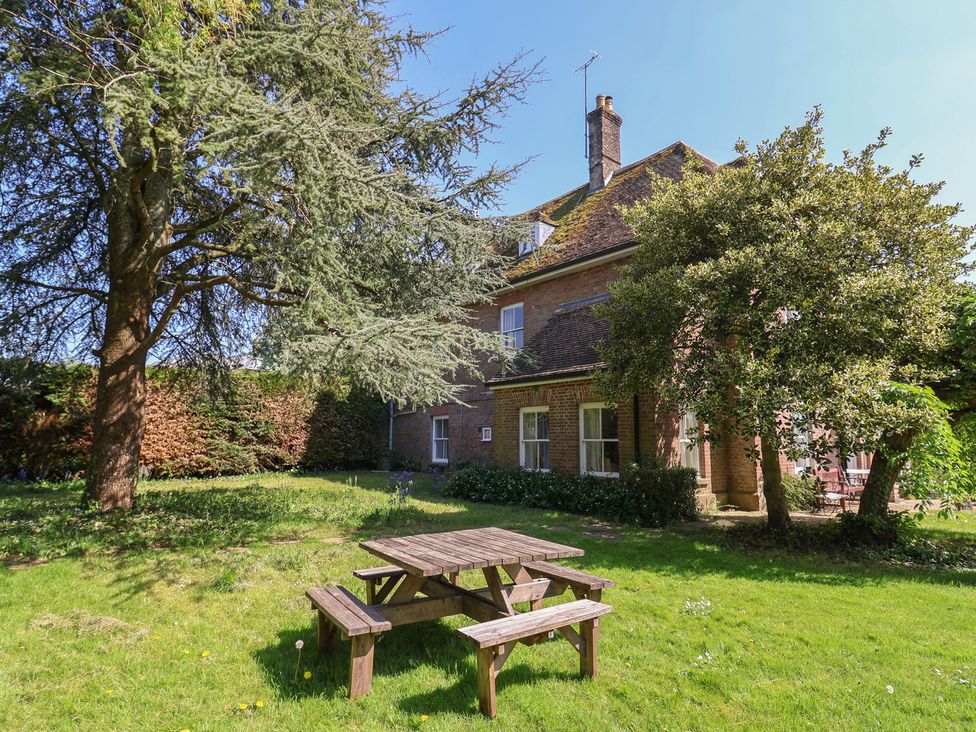 A garden with a table and benches at Goulds Farmhouse in Milborne St Andrew