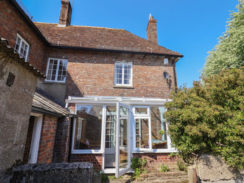 A conservatory attached to a brick house at Goulds Farmhouse in Milborne St Andrew