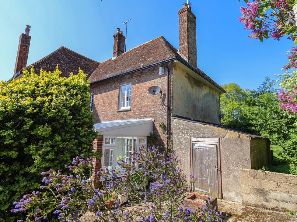 A house with flowers and a shed at Goulds Farmhouse in Milborne St Andrew