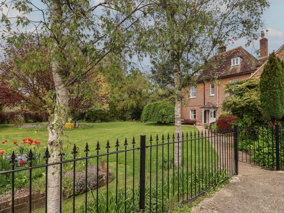 A house with a garden and fence at Goulds Farmhouse in Milborne St Andrew