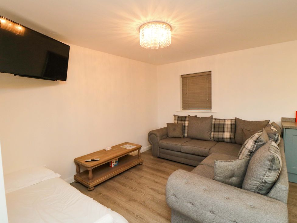 A living room with a sofa and television at Tooth Suite in Yarm
