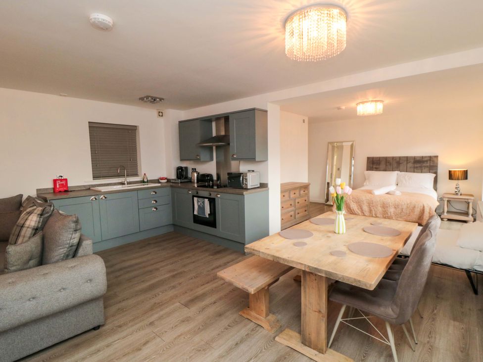 A studio apartment with a kitchen area and dining table at Tooth Suite Yarm