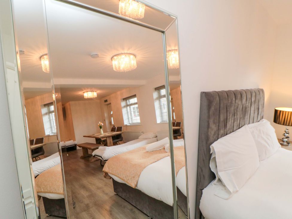 A bedroom with a bed, mirror, and table at Tooth Suite in Yarm