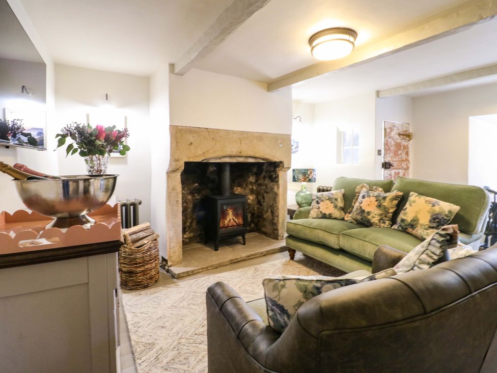 A living room with a sofa and fireplace at Hope Cottage in Great Longstone