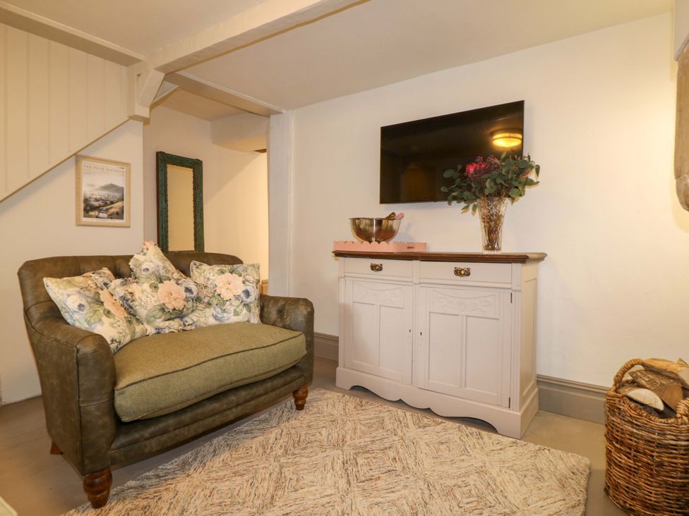 A living room with a sofa and television at Hope Cottage in Great Longstone