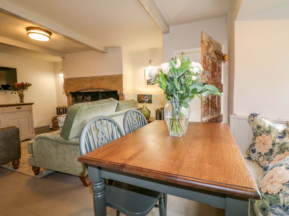 A living room with a sofa and dining table at Hope Cottage in Great Longstone