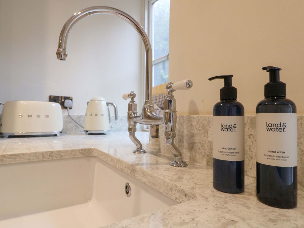 A kitchen with a sink, faucet, hand wash and lotion at Hope Cottage in Great Longstone