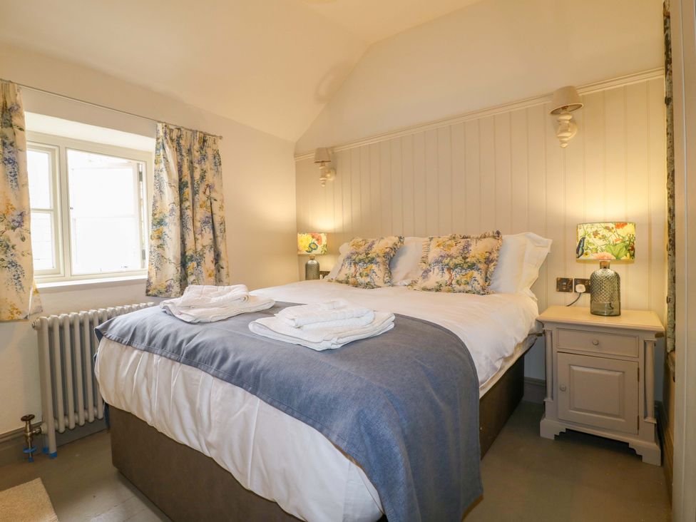 A bedroom with a bed and window at Hope Cottage in Great Longstone