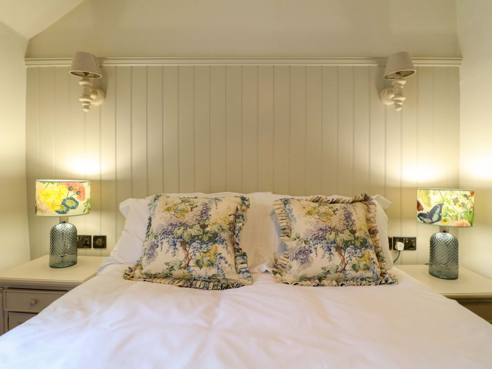 A bedroom with a bed and lamps at Hope Cottage in Great Longstone