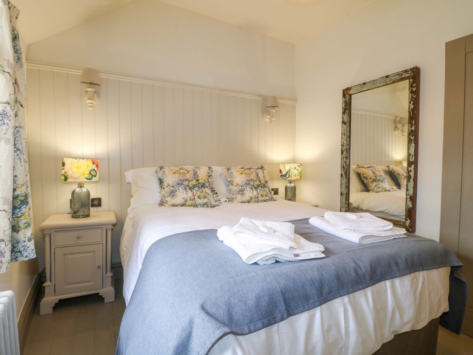 A bedroom with a bed and bedside tables at Hope Cottage in Great Longstone