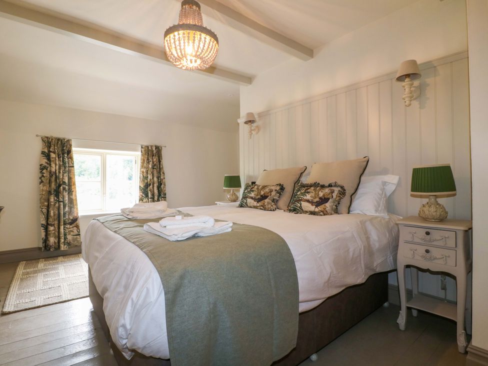A bedroom with a bed and two nightstands at Hope Cottage in Great Longstone