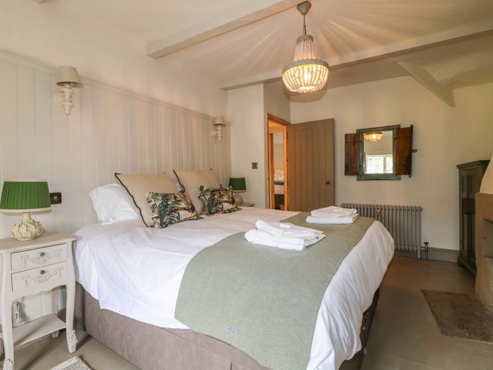 A bedroom with a double bed and bedside table at Hope Cottage in Great Longstone