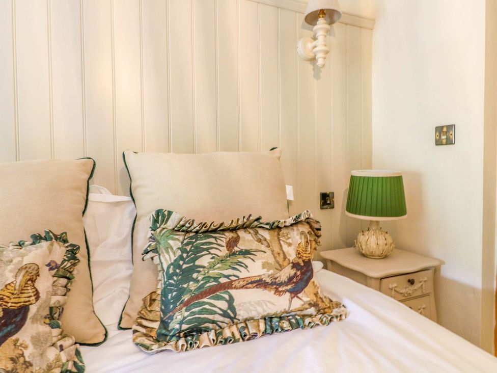 A bedroom with pillows on a bed and a lamp at Hope Cottage in Great Longstone