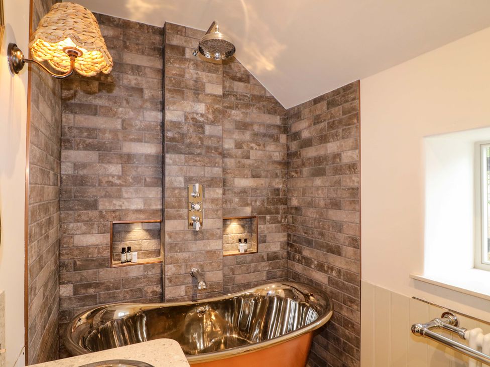 A bathroom with a bathtub and shower at Hope Cottage in Great Longstone