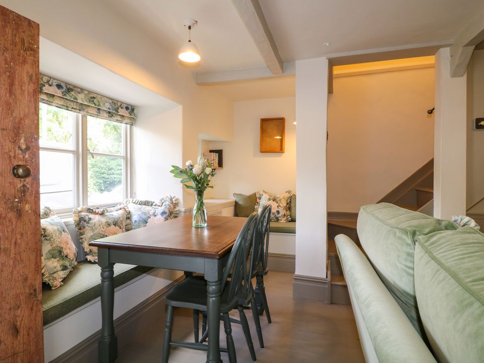 A dining room with a table and chairs at Hope Cottage in Great Longstone