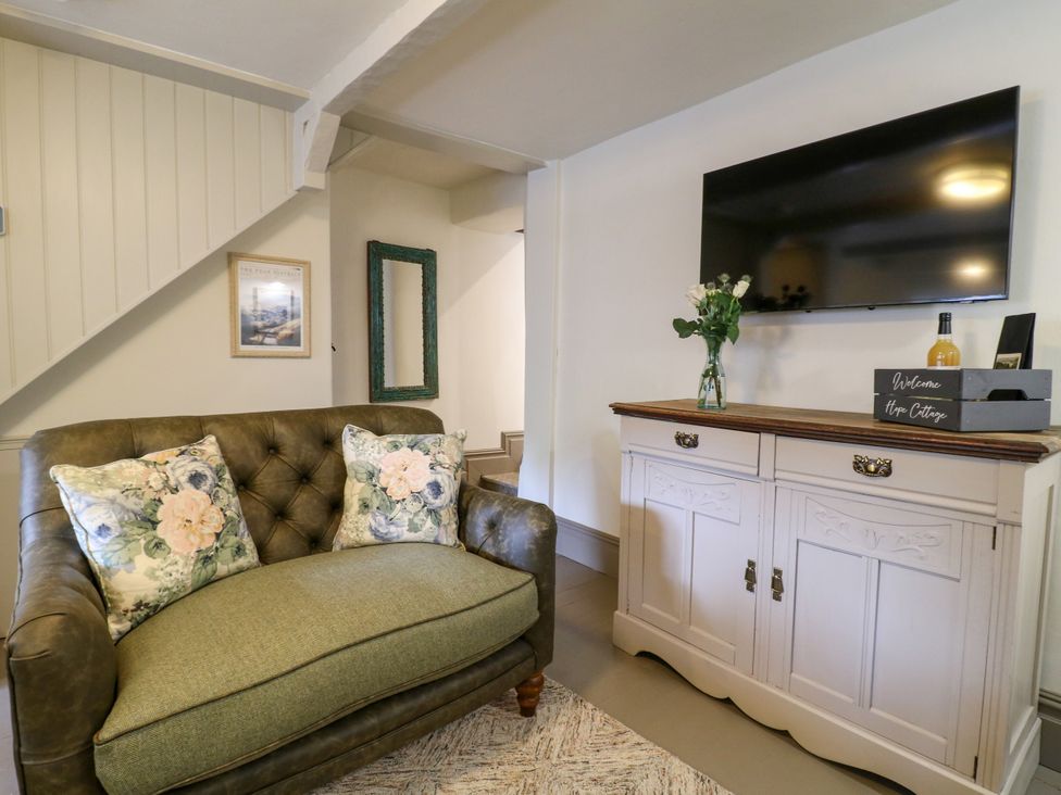 A living room with a sofa and television at Hope Cottage in Great Longstone