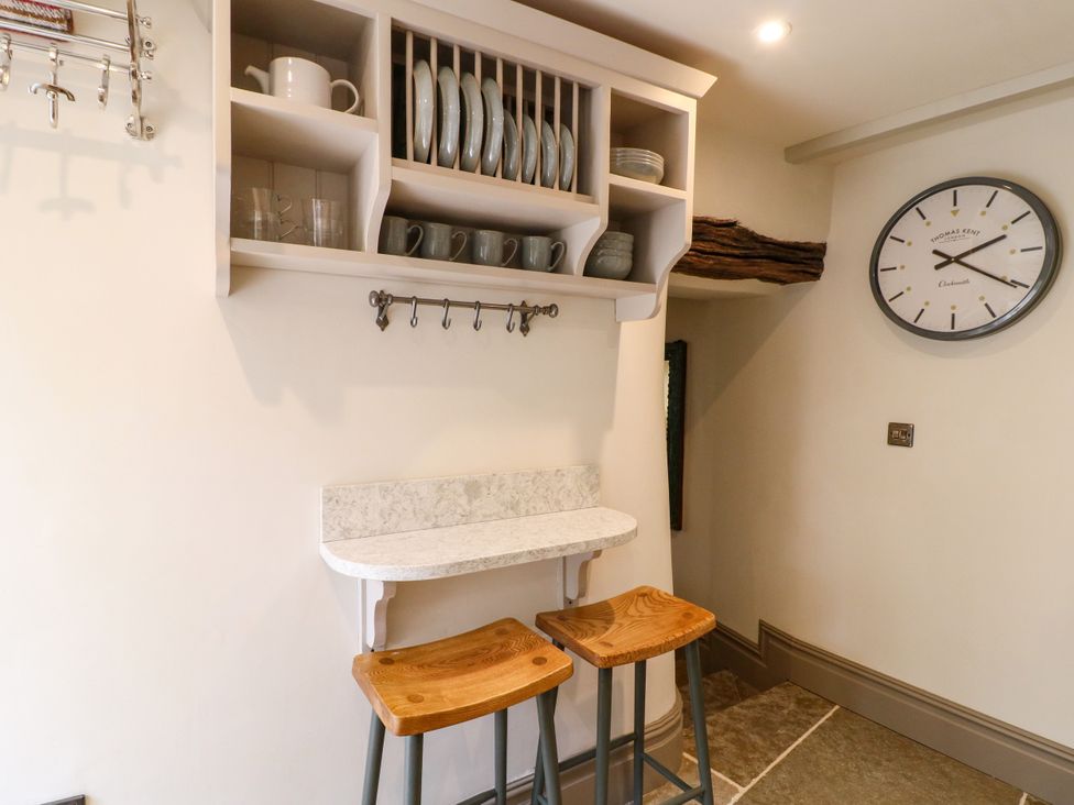 A kitchen with shelves and stools at Hope Cottage in Great Longstone
