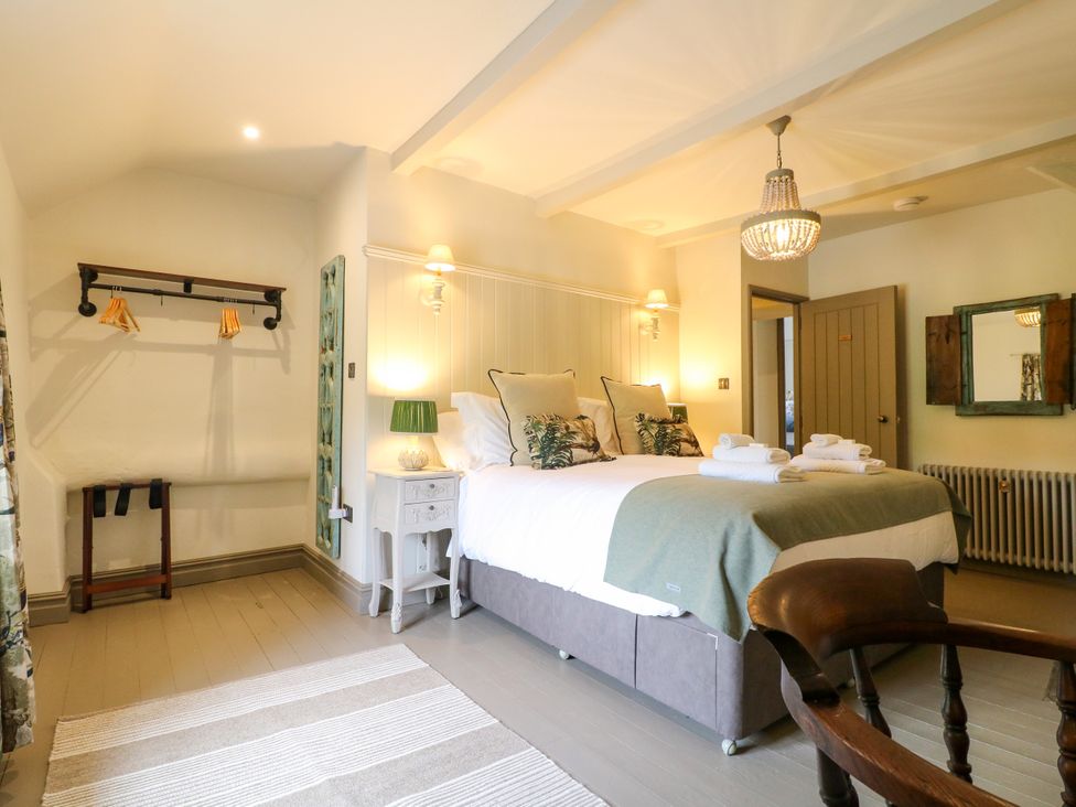 A bedroom with a bed and a coat rack at Hope Cottage in Great Longstone