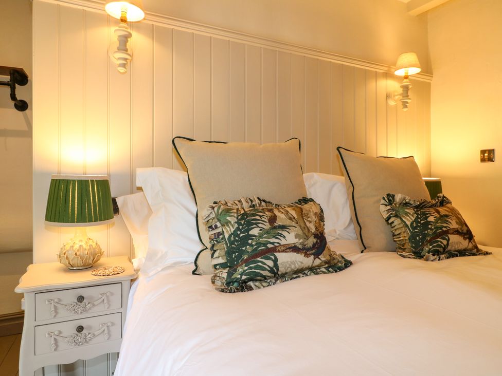 A bedroom with a bed, pillows, and lamps at Hope Cottage in Great Longstone