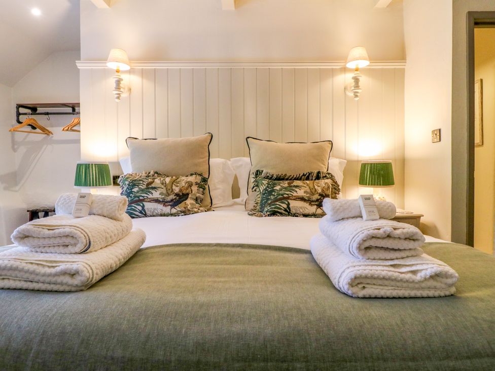 A bedroom with a bed and pillows at Hope Cottage in Great Longstone