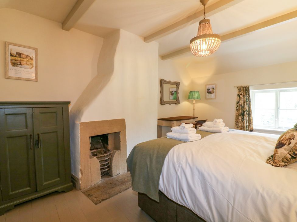 A bedroom with a bed and fireplace at Hope Cottage in Great Longstone