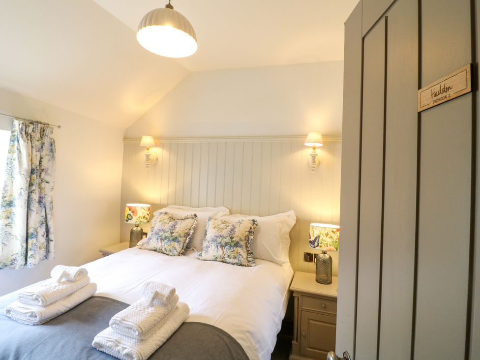 A bedroom with a double bed and bedside tables at Hope Cottage in Great Longstone