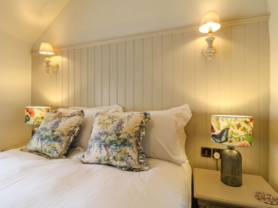 A bedroom with a bed and pillows at Hope Cottage in Great Longstone