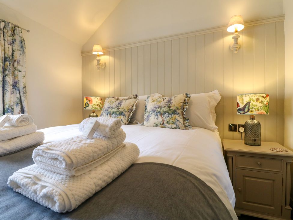 A bedroom with a bed and bedside lamps at Hope Cottage Great Longstone