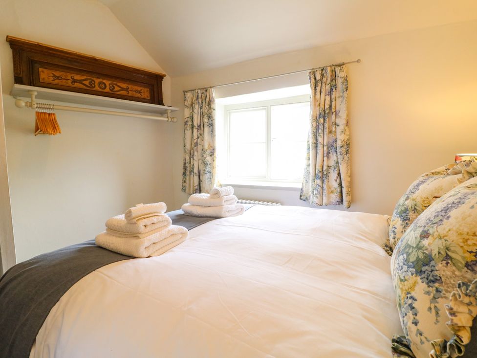 A bedroom with a bed and window at Hope Cottage in Great Longstone