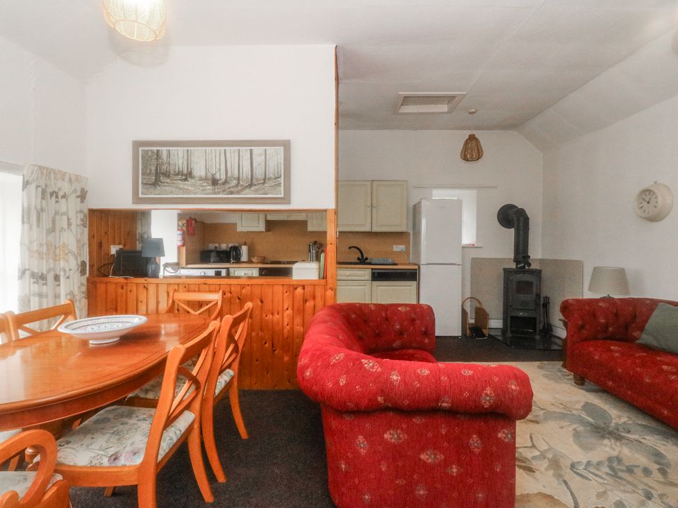A living room with dining table and kitchen area at Oak Killean Farmhouse Cottages near Inveraray
