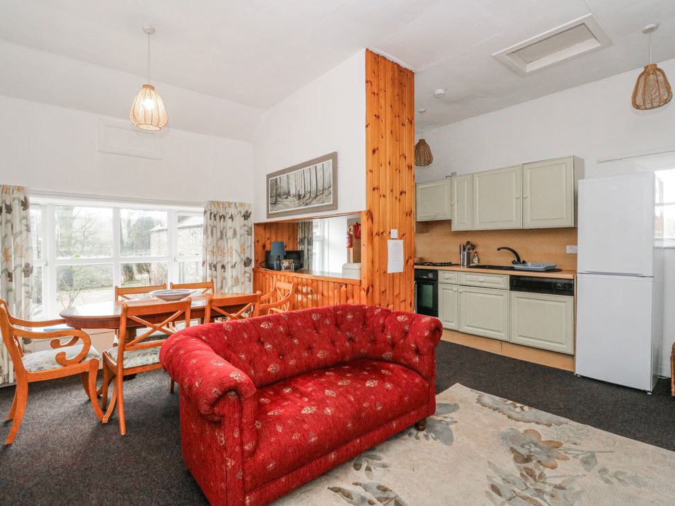 A living room with a sofa and dining area at Oak Killean Farmhouse Cottages near Inveraray