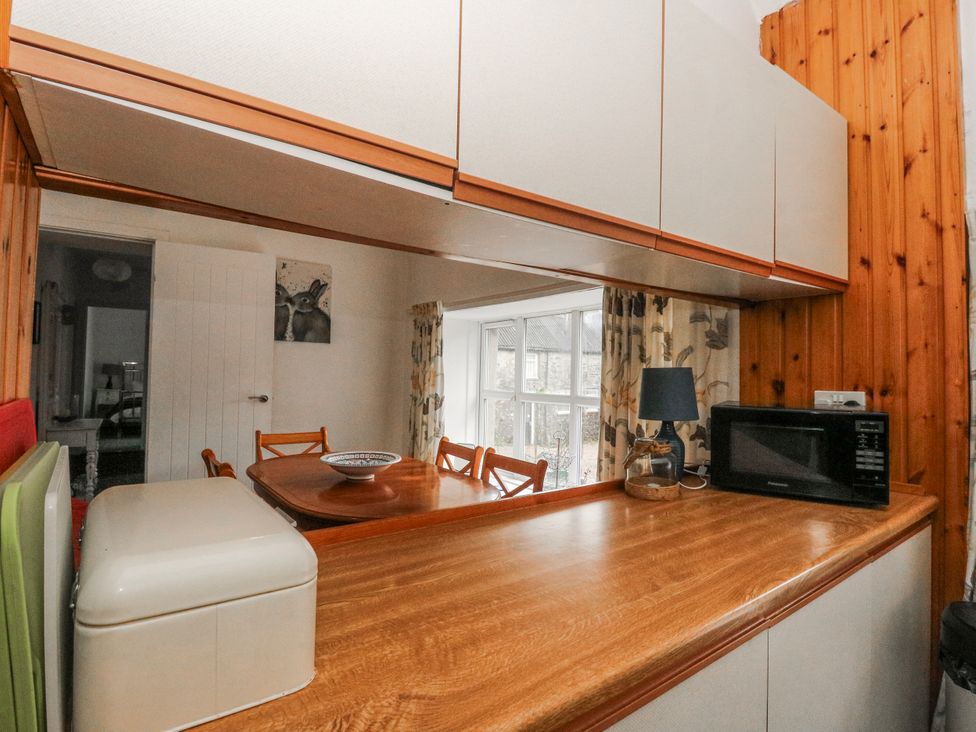 A kitchen with a table and chairs at Oak in Killean Farmhouse Cottages near Inveraray