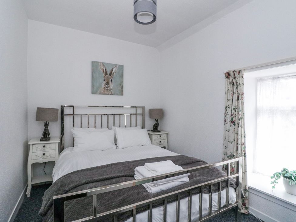 A bedroom with a bed and nightstands at Oak Killean Farmhouse Cottages near Inveraray