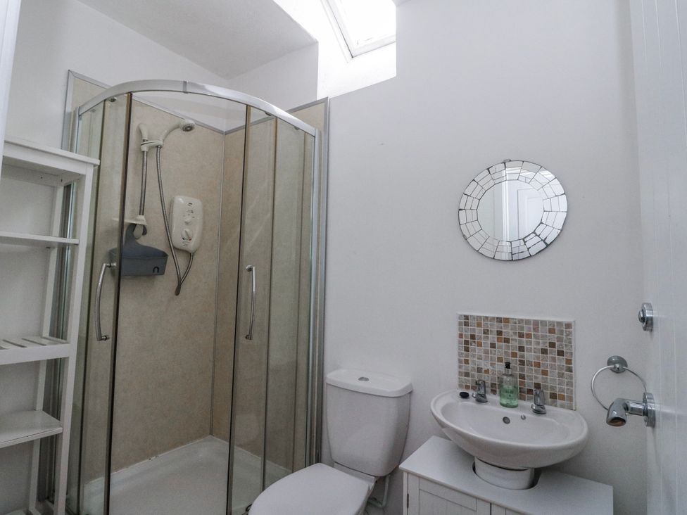 A bathroom with a shower enclosure, toilet and sink at Oak Killean Farmhouse Cottages near Inveraray