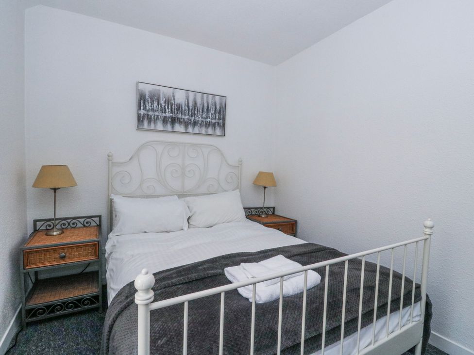 A bedroom with a bed and nightstands at Oak Killean Farmhouse Cottages near Inveraray