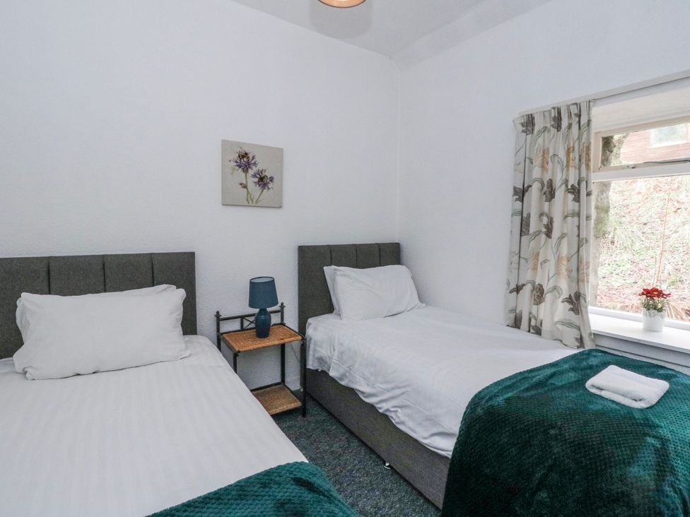 A bedroom with two beds at Oak Killean Farmhouse Cottages near Inveraray