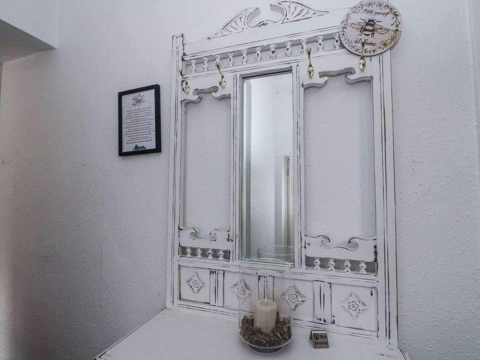 A mirror with hooks and decorative items in the hallway at Oak near Killean Farmhouse Cottages near Inveraray