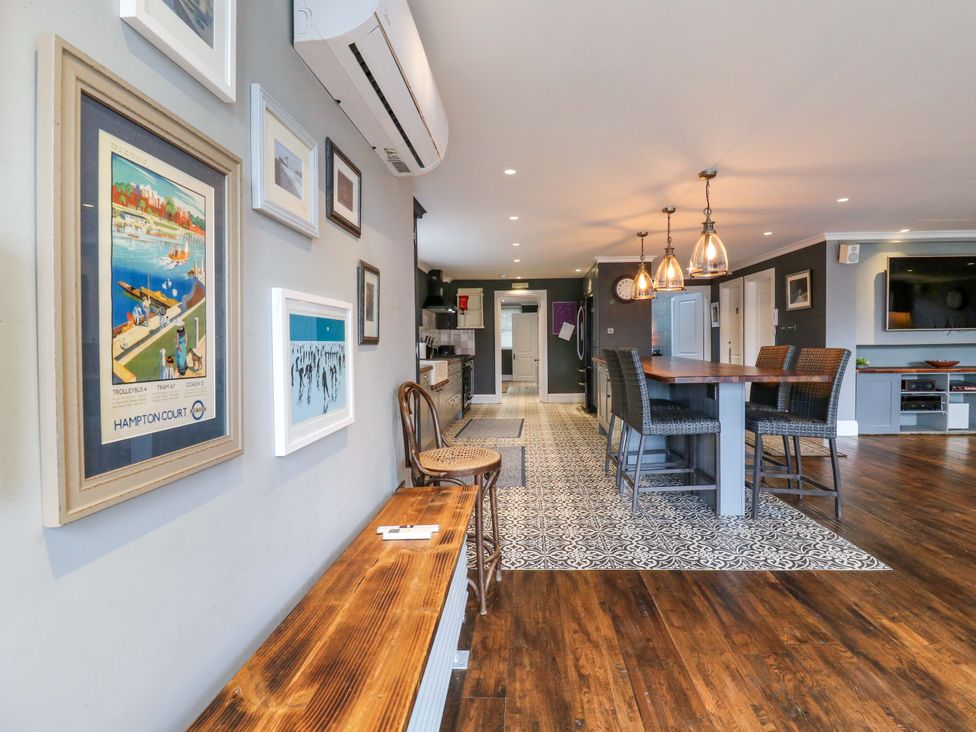 A kitchen with wall art and a dining table at River Haven in Thames Ditton