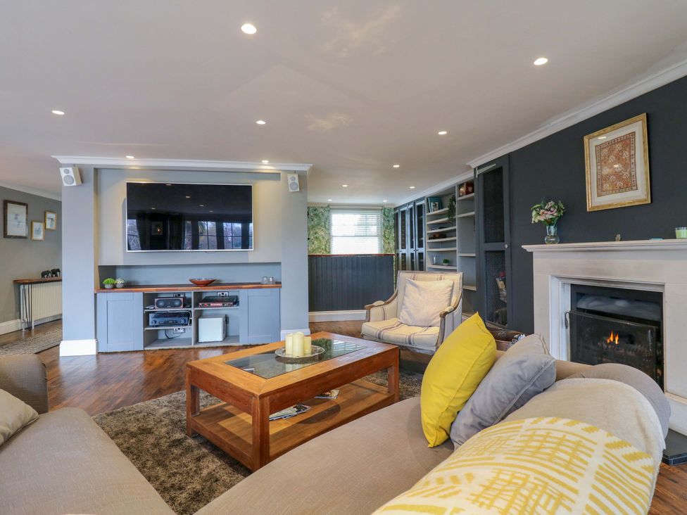 A living room with a television and fireplace at River Haven in Thames Ditton