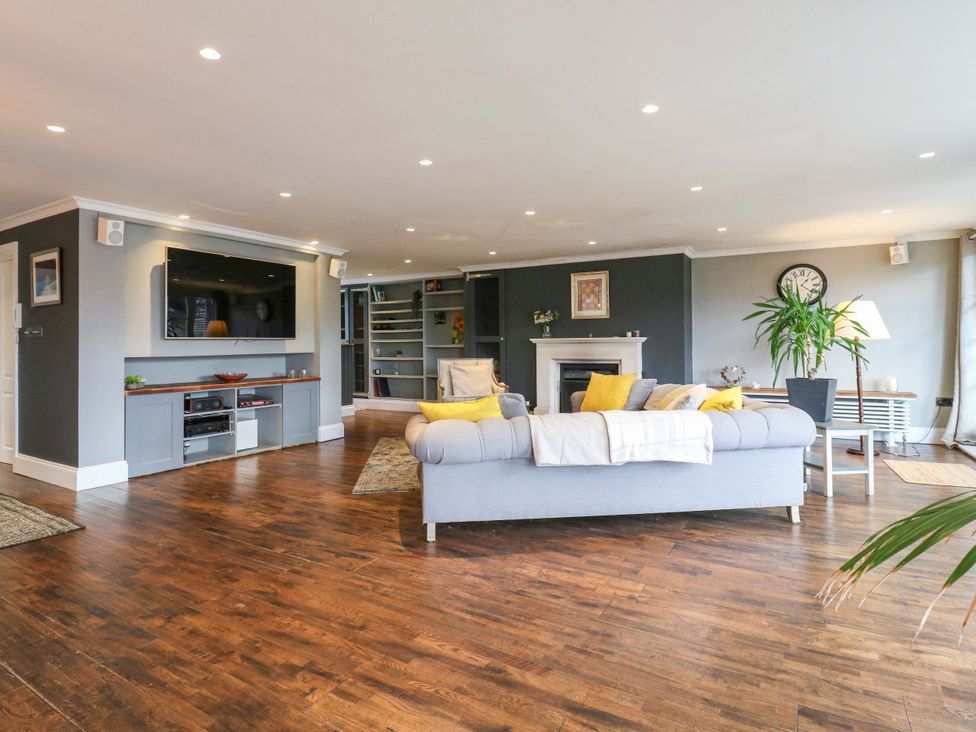 A living room with a sofa and television at River Haven Thames Ditton
