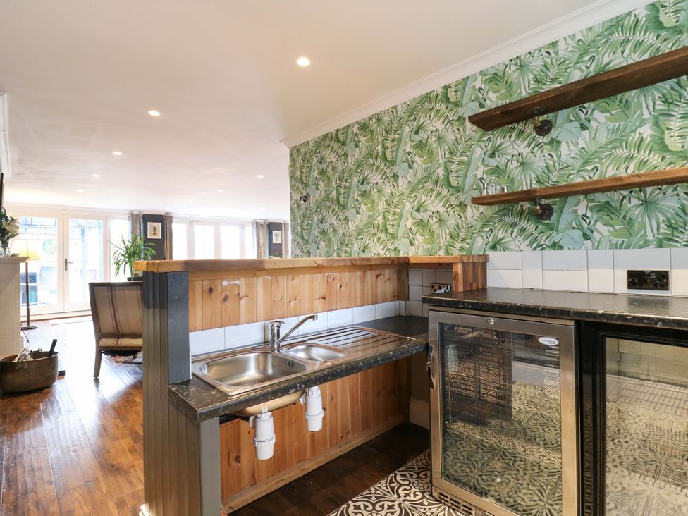A kitchen with a sink and fridge at River Haven Thames Ditton
